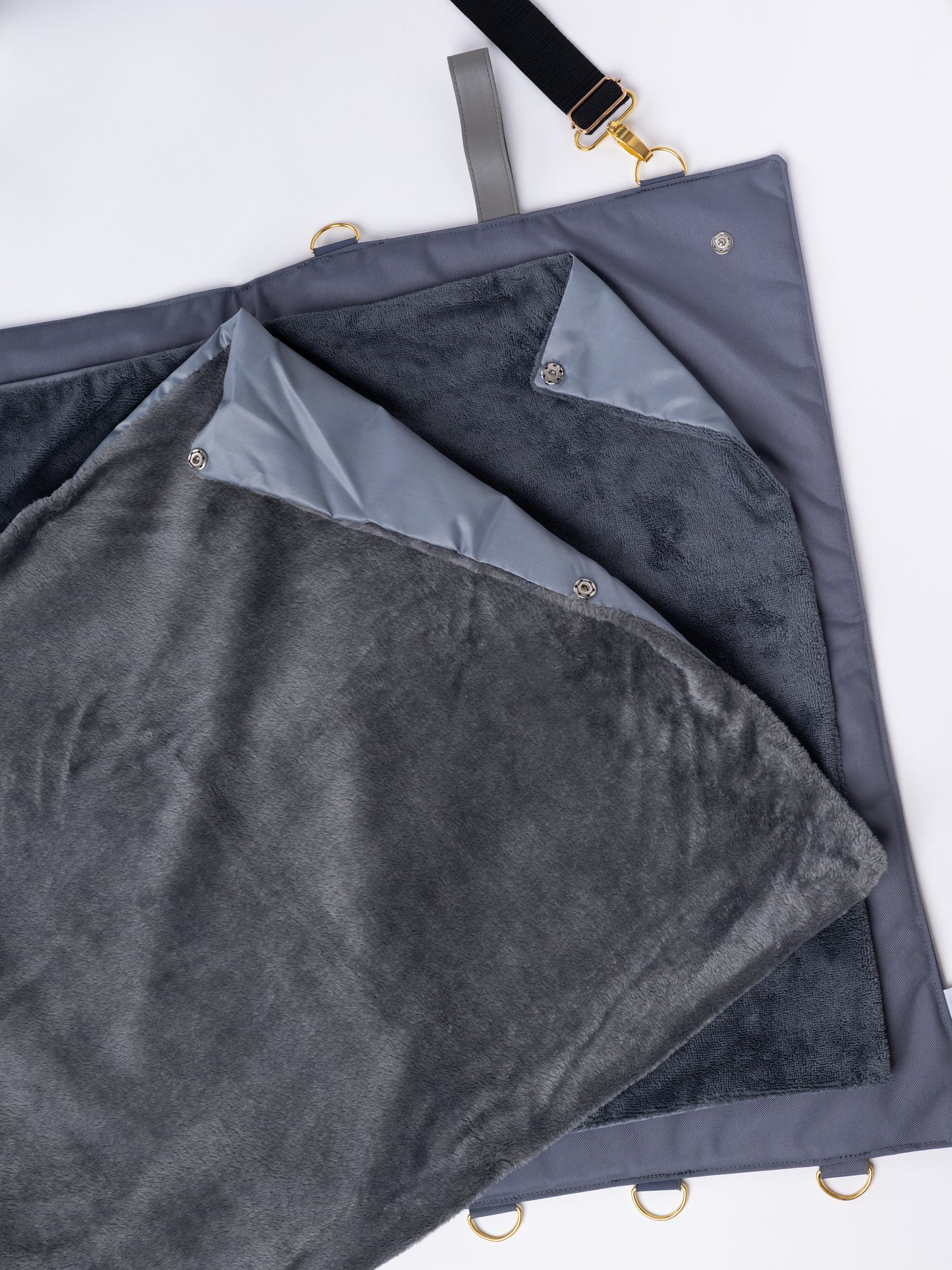 Detalhe da manta de viagem Cosmopolitan Cinza com as três opções de topo intercambiáveis: impermeável, pelo macio e toalha absorvente.
